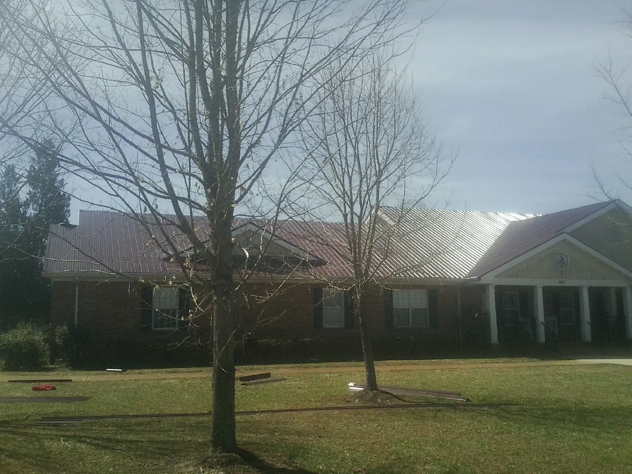 Red metal roof on a brick building seen from the front lawn in Trexlertown