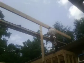 Carpenter setting a ridge beam over a new addition frame — Ice Dam Removal by Roofing Brothers in Trexlertown