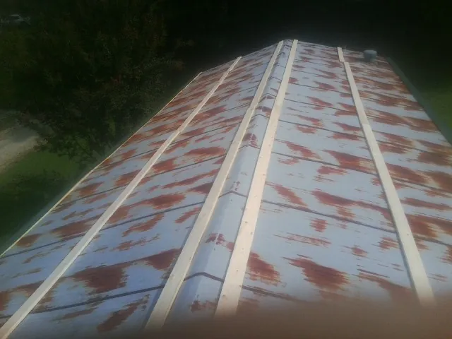 Rusted metal roof panels with new wood purlins before replacement — Storm Damage Roof Repair in Trexlertown by Roofing Brothers
