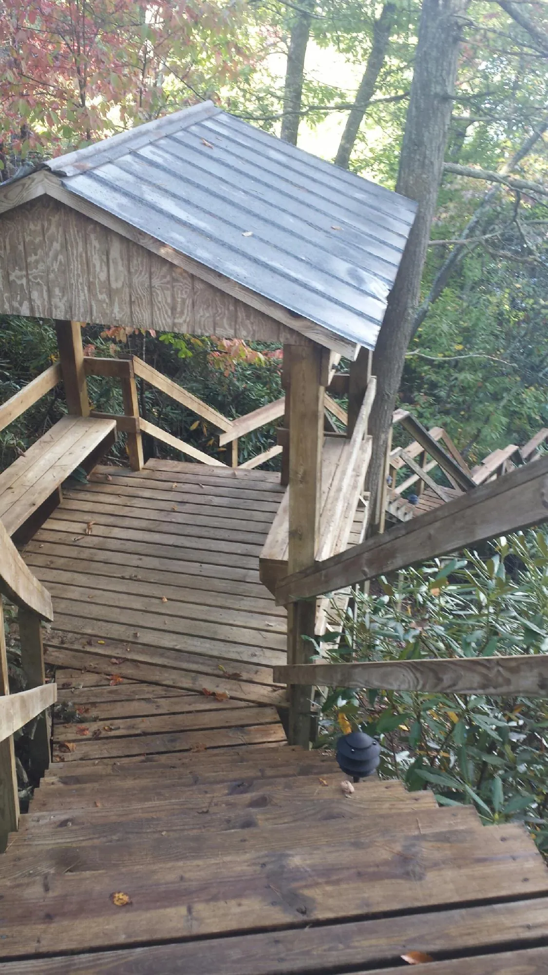 Metal roofed shelter over wooden steps on a wooded walkway — Skylight Repair & Installation work by our crew in Trexlertown