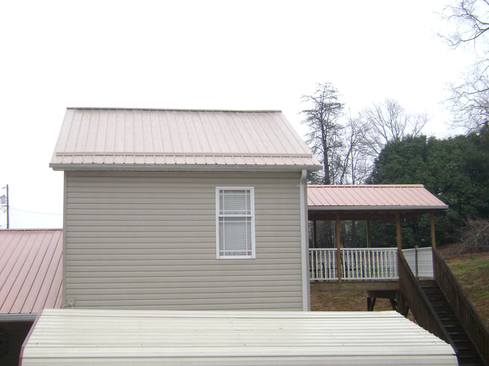 Tan metal roofs on a two story addition and attached porch, from a Roof Replacement job in Trexlertown